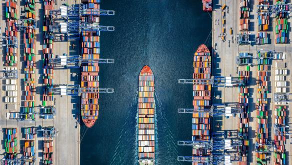 Aerial top down view of a large container cargo ship terminal with loading activity and vessel traffic