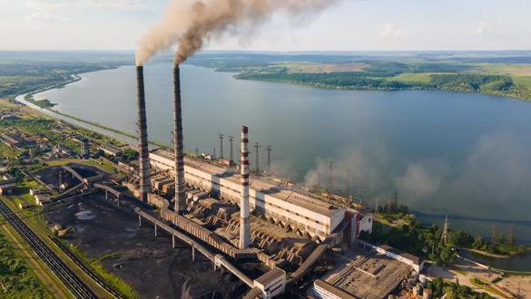 Aerial view of coal power plant high pipes with black smokestack polluting atmosphere. Electricity production with fossil fuel concept.