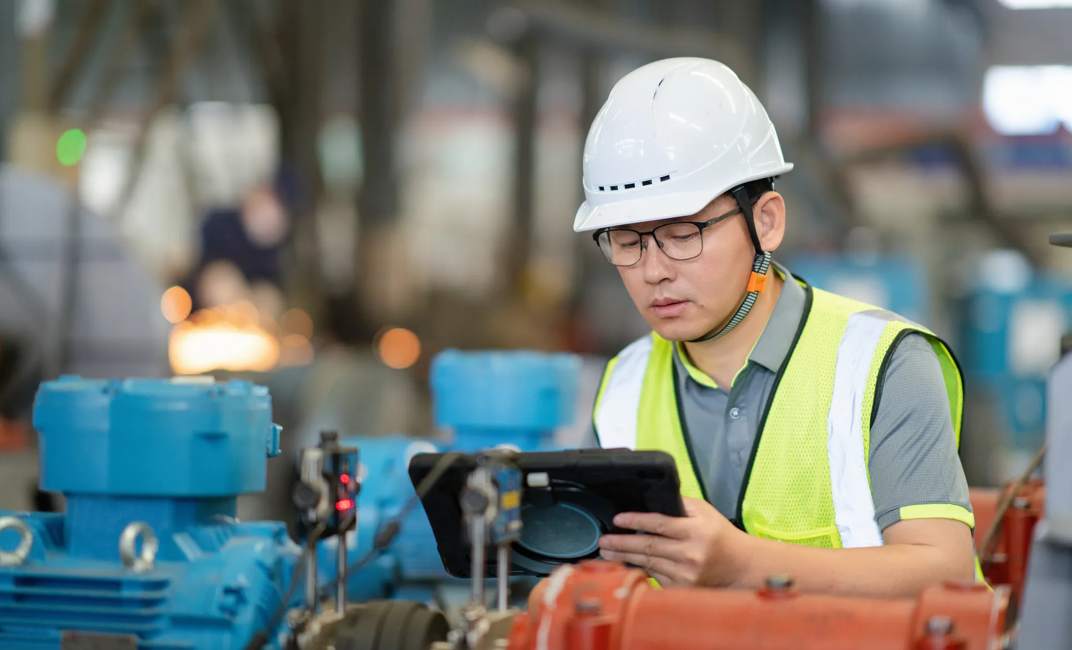 asian male engineer woking on digital tablet in factory with  Industrial fan impeller; Shutterstock ID 2627016673; purchase_order:XA-Xylem America; job:hydrovar X - Multiple Sell Sheets; client:XA; other:hydrovar X - Multiple Sell Sheets