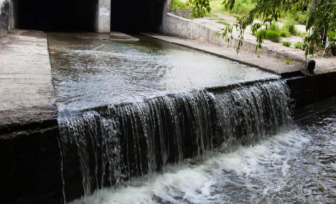Water stream flowing out the underground tunnel into the Lybid river in Kyiv.